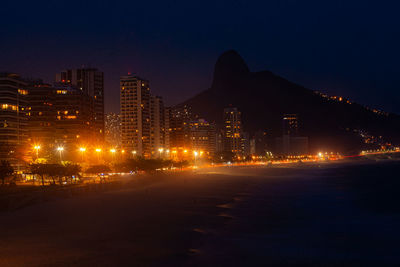 Illuminated buildings against sky at night