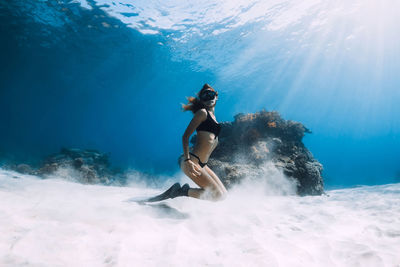 Rear view of woman swimming in sea