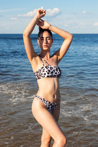 Woman in bikini standing at beach