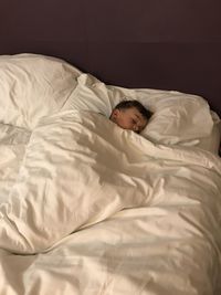 High angle view of boy sleeping on bed at home