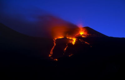 Low angle view of volcano against blue sky at night