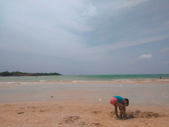 People at beach against sky