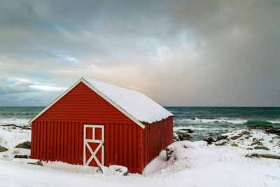Built structure by sea against sky during winter