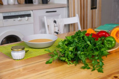 Preparing chicken stock with vegetables bouillon in a pot. black chalkboard as background.