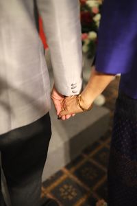 Midsection of couple holding hands