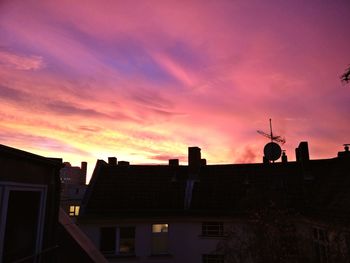 Silhouette houses against sky at sunset