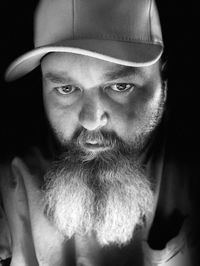 Close-up portrait of mid adult man against black background