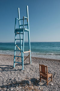 Lifeguard hut on beach against clear blue sky