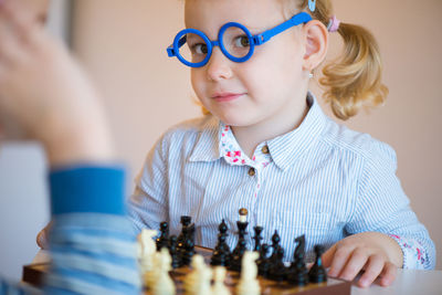 Cute sibling playing chess at home