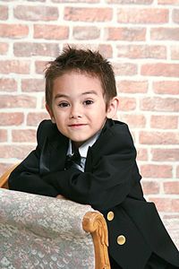 Portrait of boy smiling against brick wall