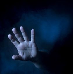 Close-up of human hand over black background