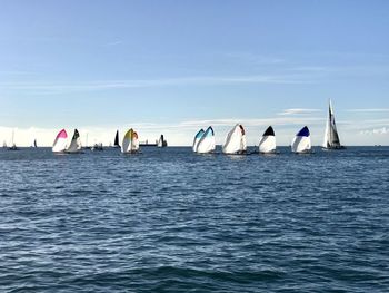 Sailboats in sea against blue sky