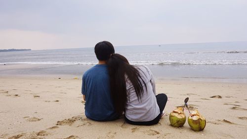 Rear view of man sitting on beach