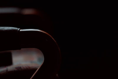 Close-up of hand holding cigarette against black background