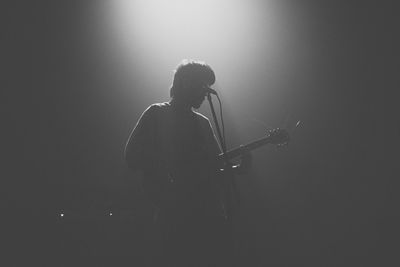 Rear view of man sitting on stage