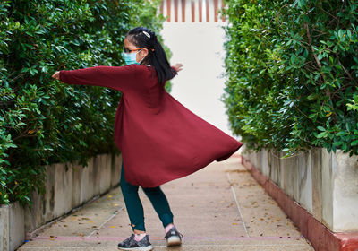 A girl who was playful and wears a mask in a public park during covid-19 pandemic 