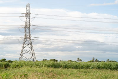 Electricity pylon on field against sky