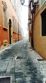 Cobblestone street amidst buildings in city