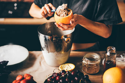 Midsection of woman holding drink on table