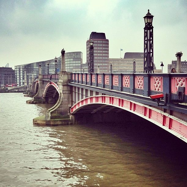 architecture, built structure, building exterior, bridge - man made structure, connection, city, river, water, waterfront, sky, transportation, travel destinations, bridge, capital cities, travel, international landmark, famous place, cloud - sky, tourism, incidental people