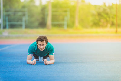 Portrait of young man exercising at stadium