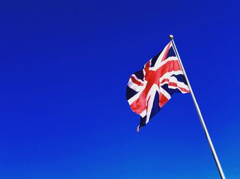 Low angle view of british flag against clear blue sky