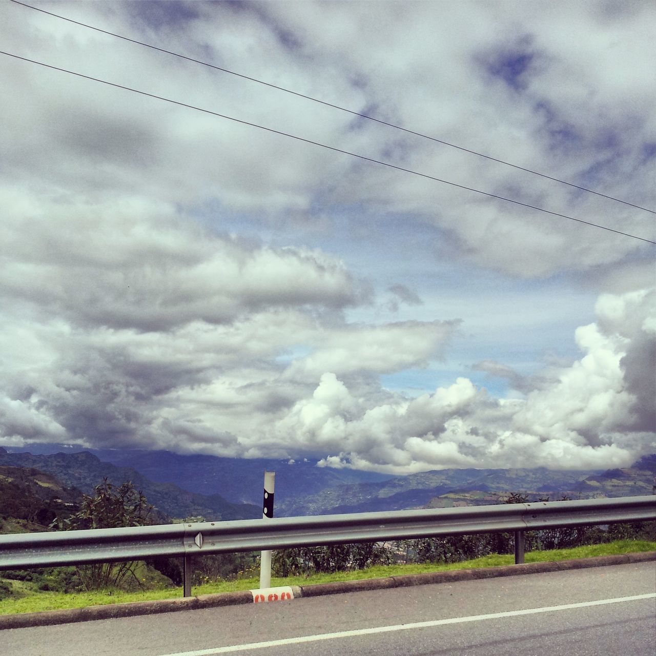 sky, cloud - sky, railing, cloudy, cloud, water, weather, road, nature, mountain, bridge - man made structure, one person, tranquility, built structure, day, transportation, overcast, connection, scenics, tranquil scene