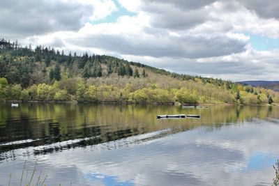 Scenic view of lake by trees against sky