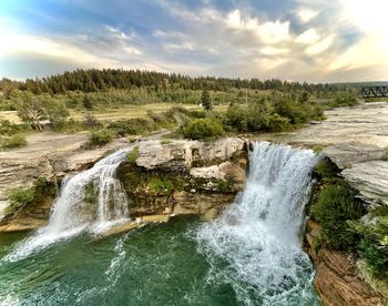 Scenic view of waterfall against sky