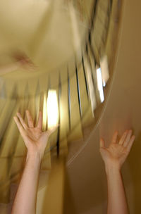 Cropped image of woman with arms raised against stairs