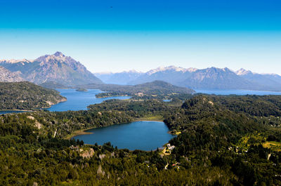 Scenic view of lake and mountains against blue sky