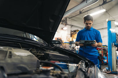 Mechanic holding equipment in garage