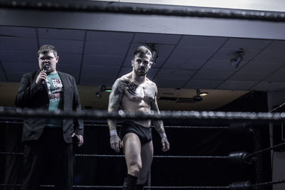 Wrestler standing by reefer at fighting ring