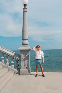 Full length of woman standing against sea and sky