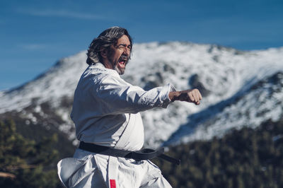 Senior man practicing karate outdoors