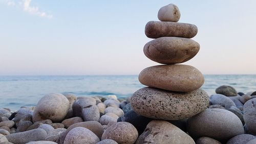 Stack of pebbles on beach against clear sky