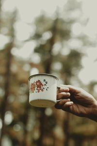 Cropped hand holding coffee cup