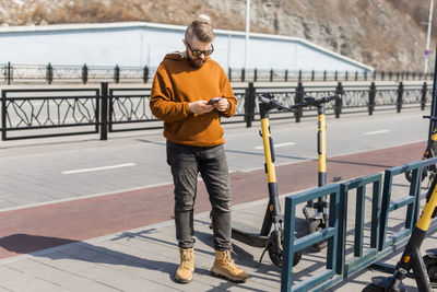 Full length of young man standing on bridge