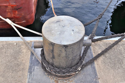 High angle view of rope tied to bollard at harbor