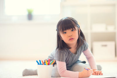 Portrait of a girl with toy sitting at home