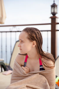 Close-up girl looking away sitting outdoors