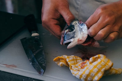 Close-up of person preparing fish on table