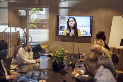 Businesswoman discussing through video conference with colleagues at office