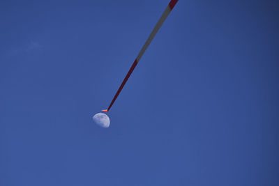 Low angle view of lighting equipment against clear blue sky