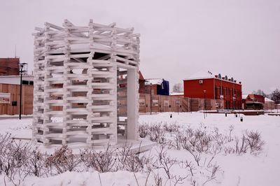 Houses on snow covered field against sky