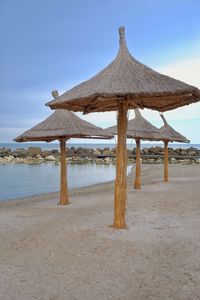 Traditional windmill on beach against sky