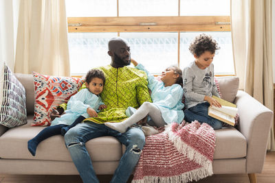 Cute kids with father sitting at home