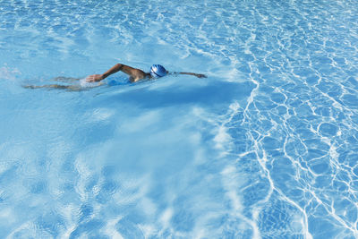 Woman swimming in clear blue swimming pool