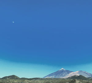 Scenic view of mountains against clear blue sky