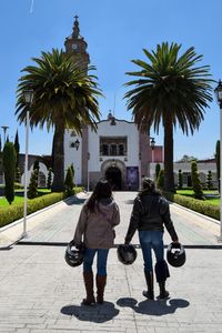 Rear view of female friends standing on footpath leading towards church